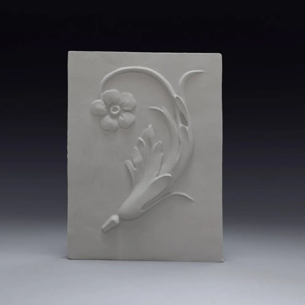 Bas-relief en plâtre d'une feuille d'acanthe avec une fleur.