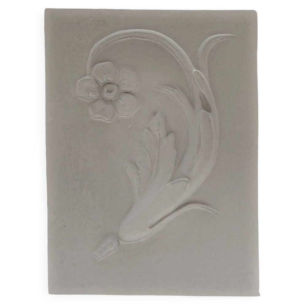 Bas-relief en plâtre d'une feuille d'acanthe avec une fleur.