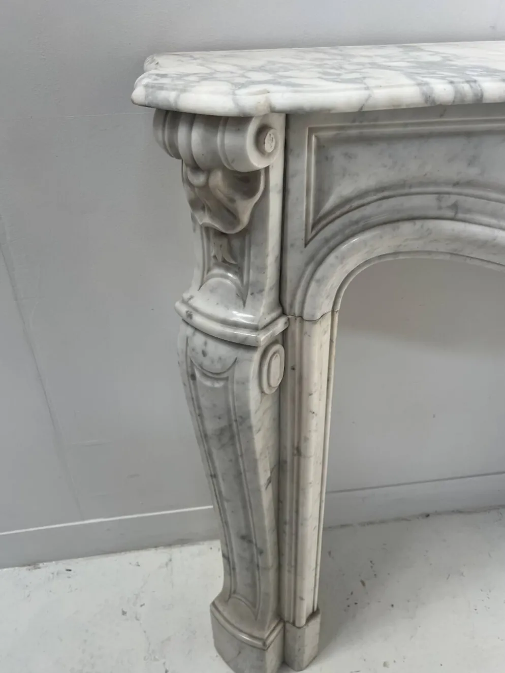 Cheminée de style Louis XV en marbre blanc veiné de Carrare XIX siècle