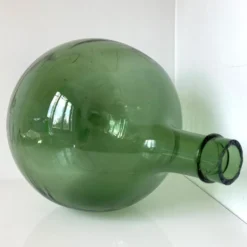 Dame Jeanne ancienne en verre vert à col bagué et ouverture martelée