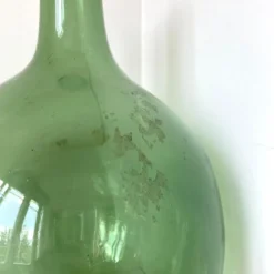 Dame Jeanne ancienne en verre vert à col bagué et ouverture martelée