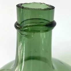 Dame Jeanne ancienne en verre vert à col bagué et ouverture martelée