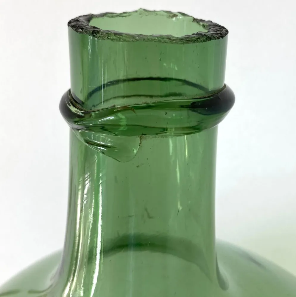 Dame Jeanne ancienne en verre vert à col bagué et ouverture martelée
