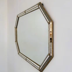 Grand miroir mural octogonal en métal doré espagnol et mosaïque biseautée, style Hollywood Regency.