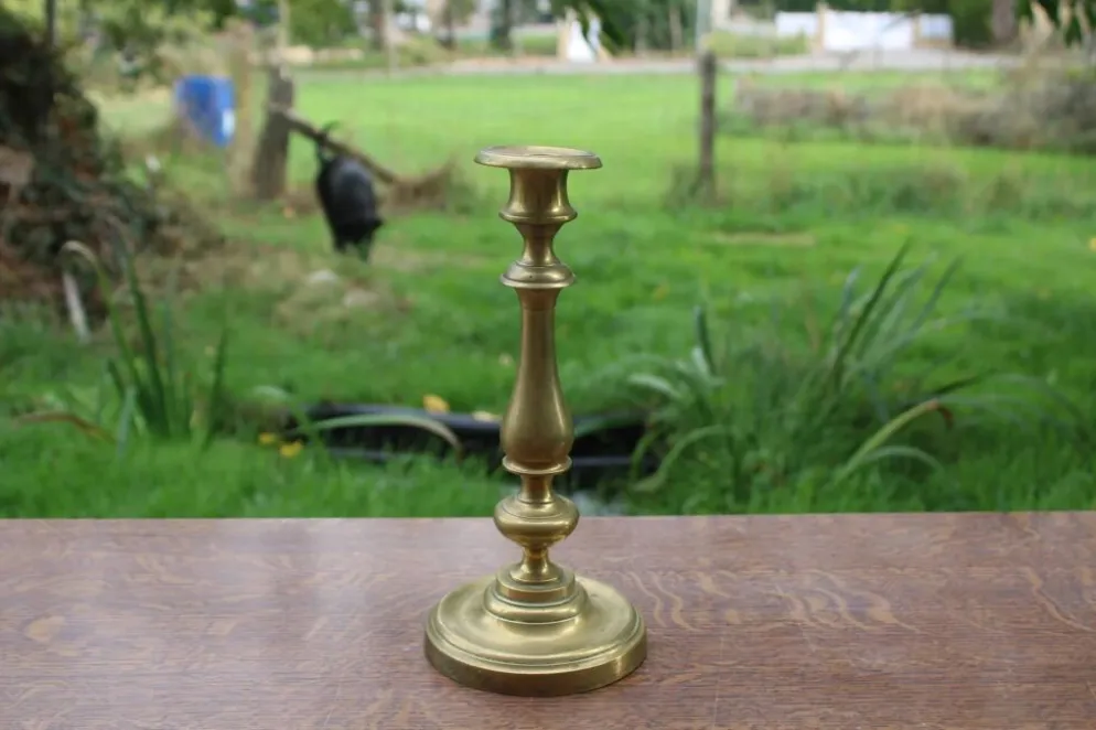 Élégant bougeoir ancien en laiton, à la silhouette élancée et au joli travail de tournage.