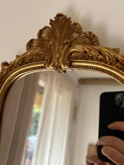 Miroir décoratif avec moulures et fronton.