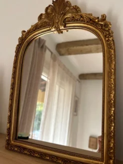 Miroir décoratif avec moulures et fronton.