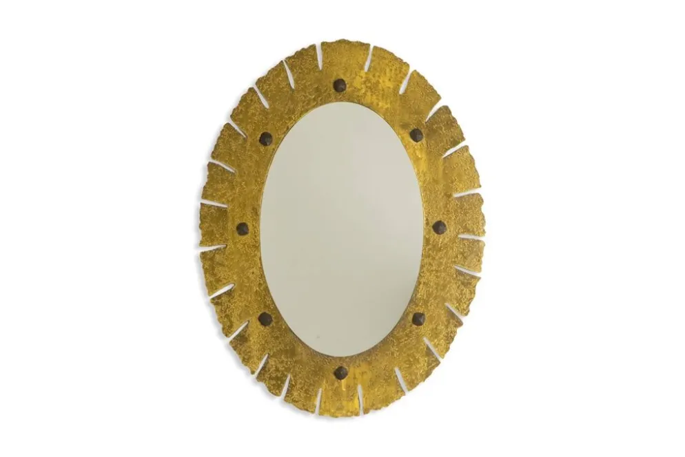 Miroir de forme elliptique en laiton martelé et doré. Années 1950-60.