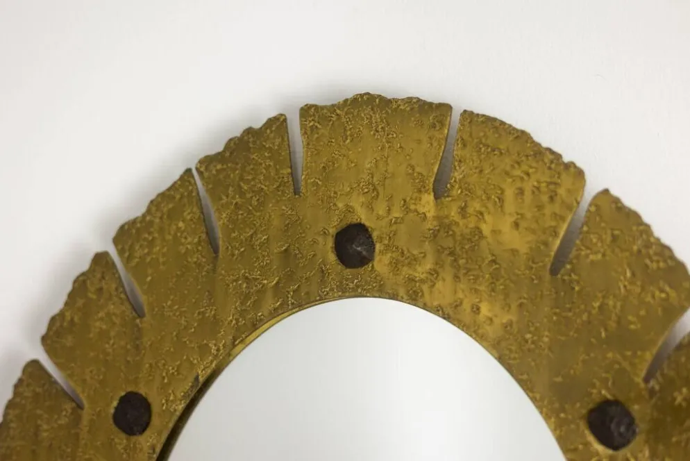 Miroir de forme elliptique en laiton martelé et doré. Années 1950-60.