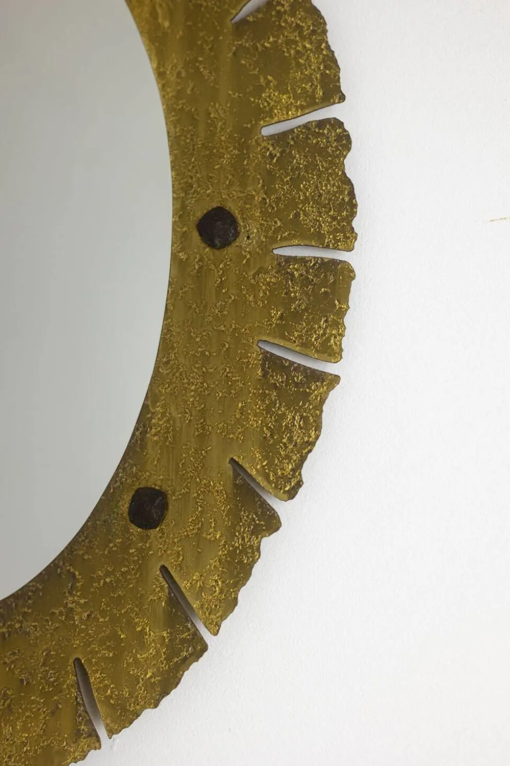 Miroir de forme elliptique en laiton martelé et doré. Années 1950-60.