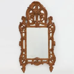 Miroir en bois doré sculpté de style Louis XV avec un fronton floral, France, 18ème siècle.