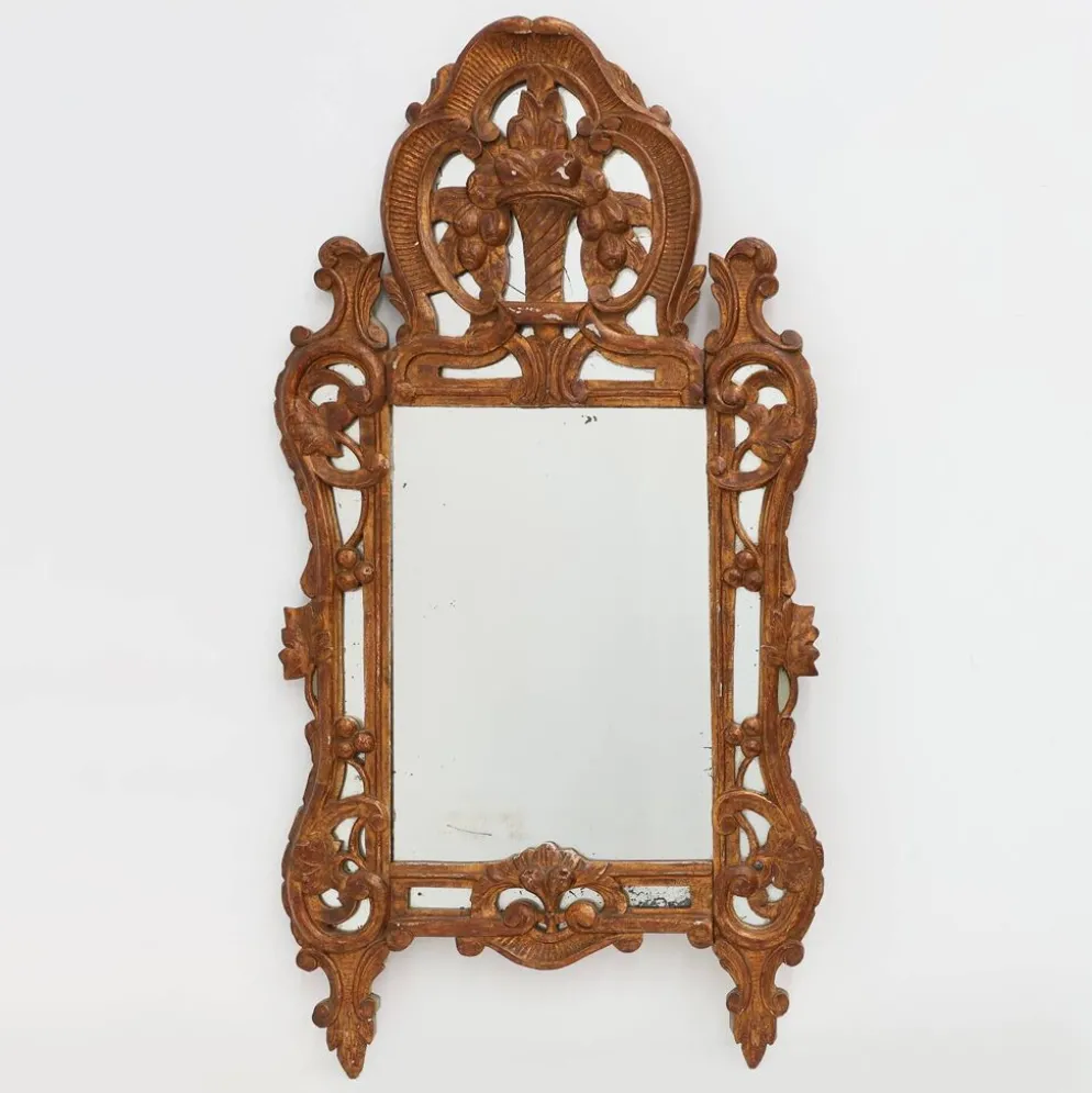 Miroir en bois doré sculpté de style Louis XV avec un fronton floral, France, 18ème siècle.