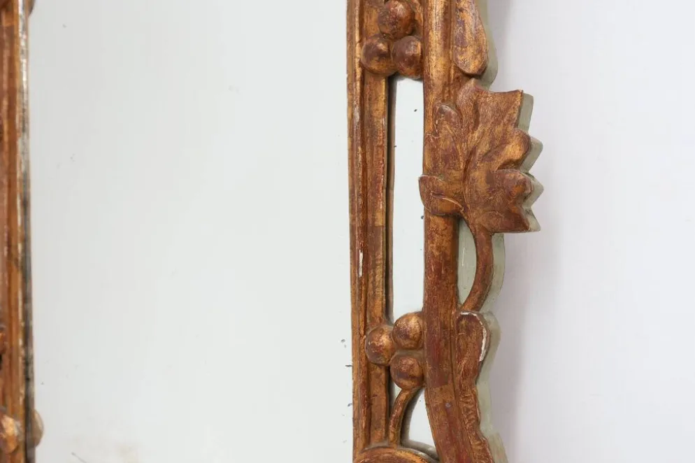 Miroir en bois doré sculpté de style Louis XV avec un fronton floral, France, 18ème siècle.