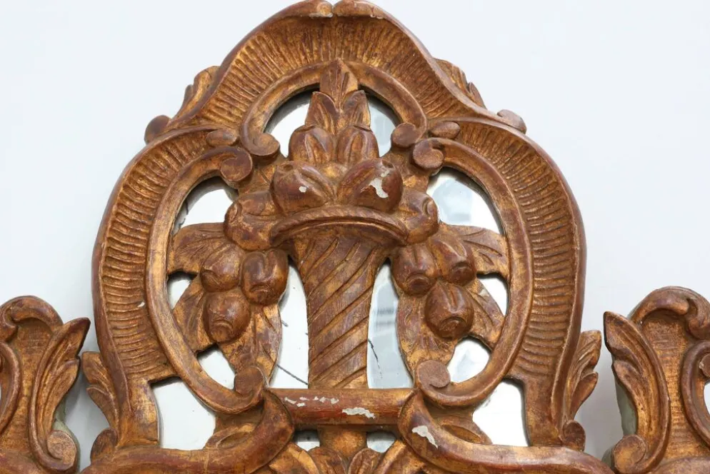 Miroir en bois doré sculpté de style Louis XV avec un fronton floral, France, 18ème siècle.