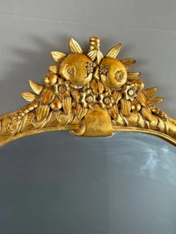Miroir en bois sculpté et doré à décor de fruits et de fleurs, XXe siècle