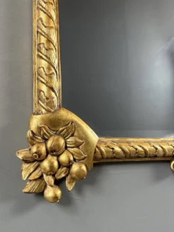 Miroir en bois sculpté et doré à décor de fruits et de fleurs, XXe siècle