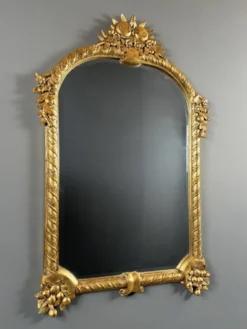 Miroir en bois sculpté et doré à décor de fruits et de fleurs, XXe siècle