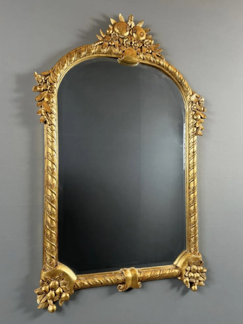 Miroir en bois sculpté et doré à décor de fruits et de fleurs, XXe siècle
