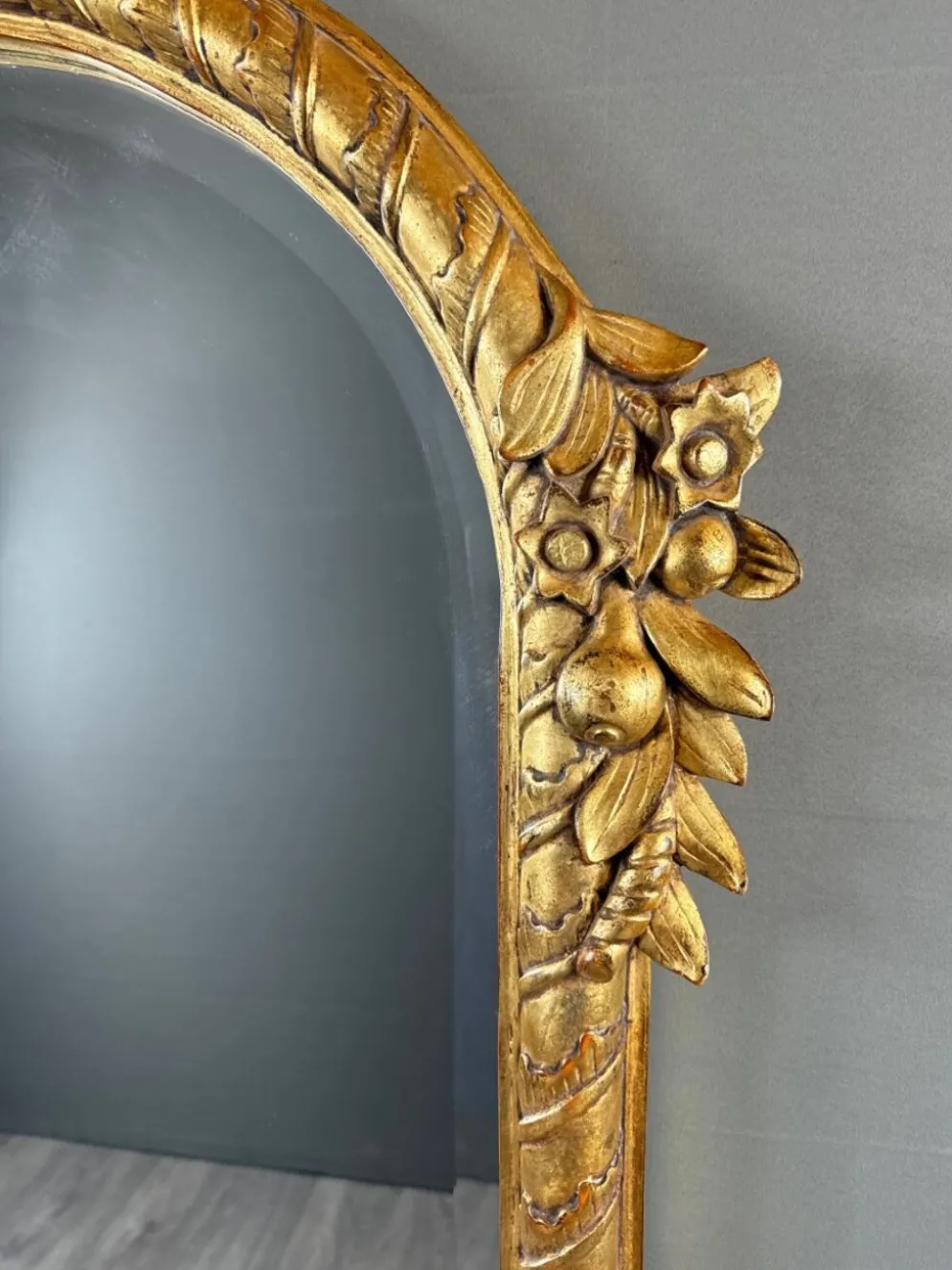 Miroir en bois sculpté et doré à décor de fruits et de fleurs, XXe siècle
