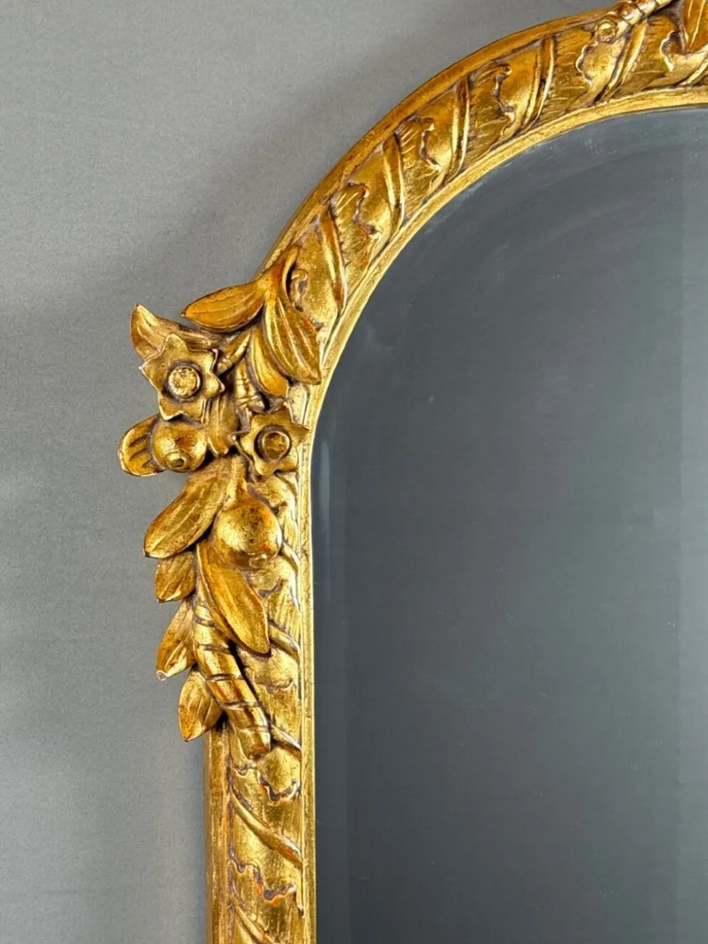 Miroir en bois sculpté et doré à décor de fruits et de fleurs, XXe siècle
