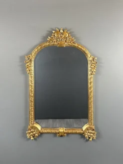 Miroir en bois sculpté et doré à décor de fruits et de fleurs, XXe siècle