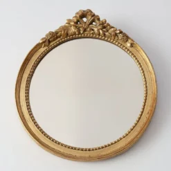 Miroir ovale en bois doré avec un fronton floral de style rococo, milieu du 20e siècle