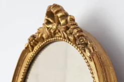 Miroir ovale en bois doré avec un fronton floral de style rococo, milieu du 20e siècle