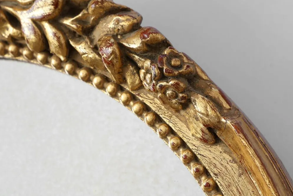 Miroir ovale en bois doré avec un fronton floral de style rococo, milieu du 20e siècle