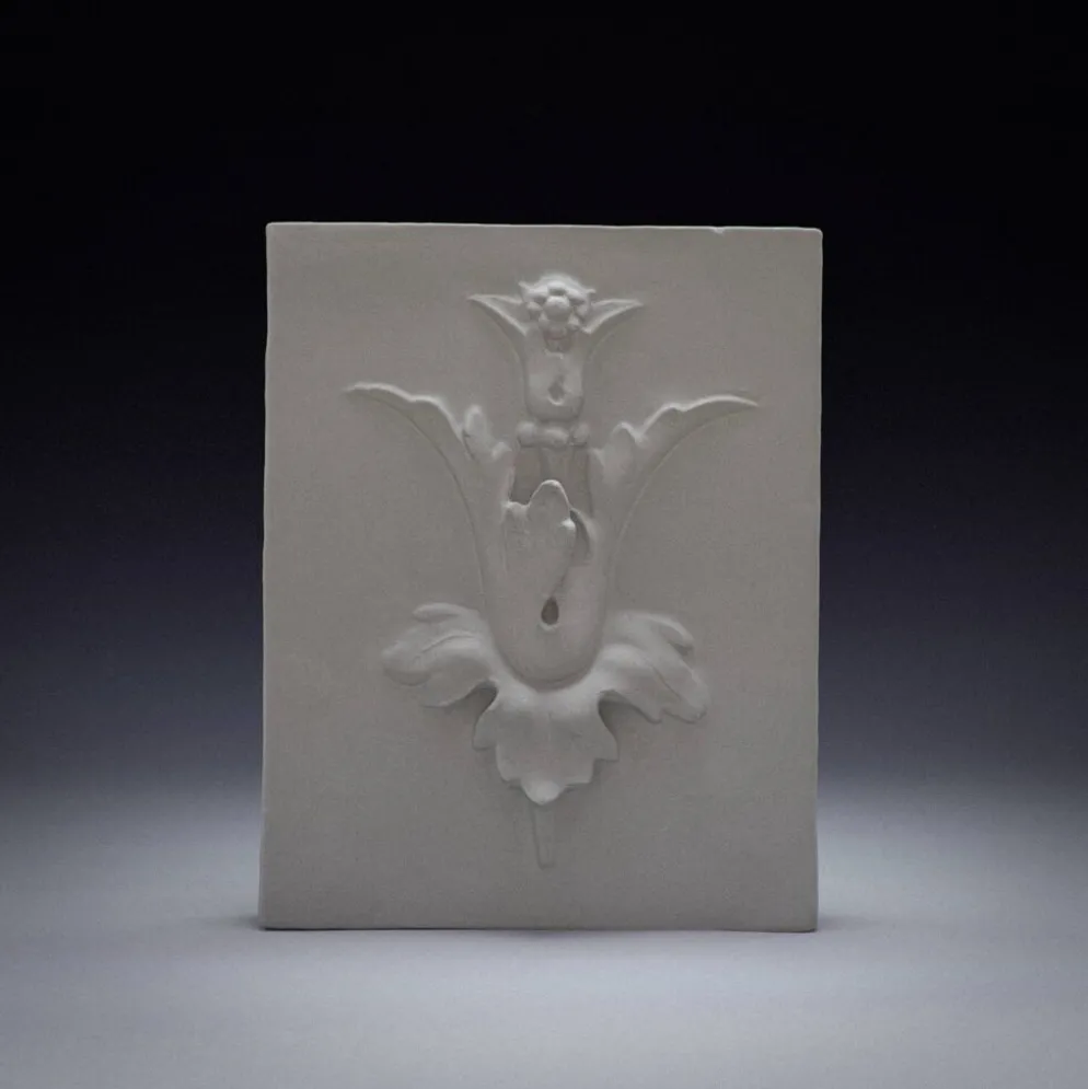 Mural en plâtre en bas-relief avec un motif de fleur de lys.