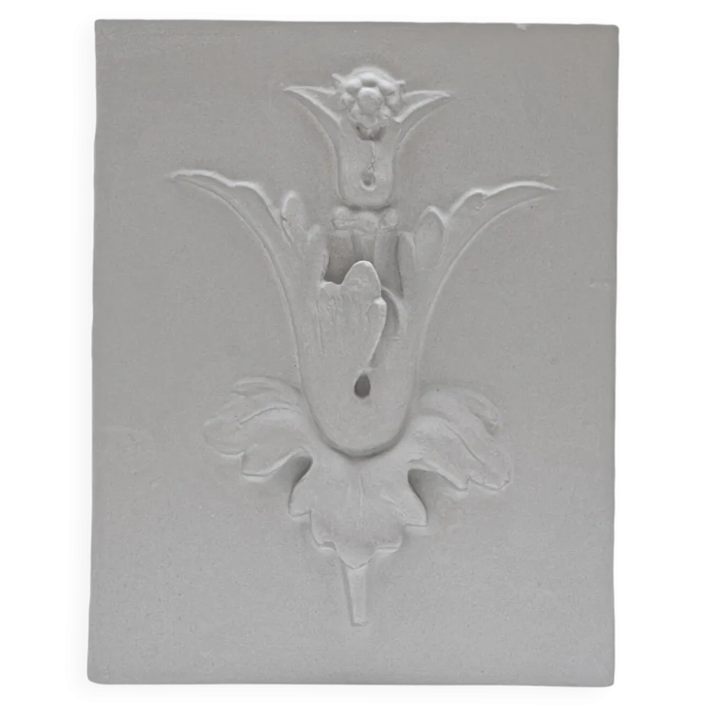 Mural en plâtre en bas-relief avec un motif de fleur de lys.