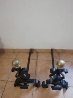 Paire de chenets en fer forgé et boule en laiton.
