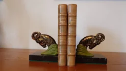 Paire de serre-livres Art Déco têtes de bélier, métal patiné et marbre noir