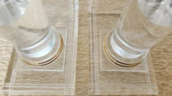 Paire de serre-livres colonnes en plexiglas et métal doré, design années 80