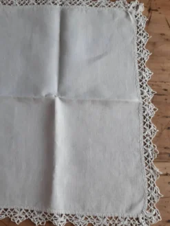 Petite nappe en fil bordée de décor au crochet fin. Années 30.