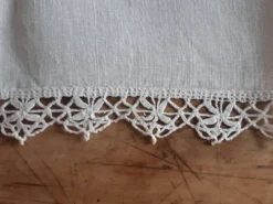 Petite nappe en fil bordée de décor au crochet fin. Années 30.