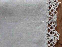 Petite nappe en fil bordée de décor au crochet fin. Années 30.