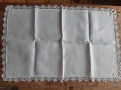 Petite nappe en fil bordée de décor au crochet fin. Années 30.