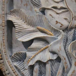Sculpture en bas-relief, visage stylisé avec des fleurs, 20e siècle