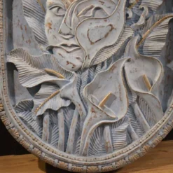 Sculpture en bas-relief, visage stylisé avec des fleurs, 20e siècle
