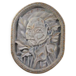 Sculpture en bas-relief, visage stylisé avec des fleurs, 20e siècle