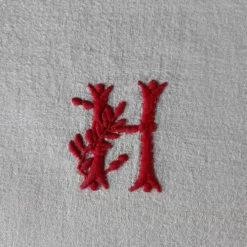 Serviette dammassée rouge et blanc avec initiale "h"