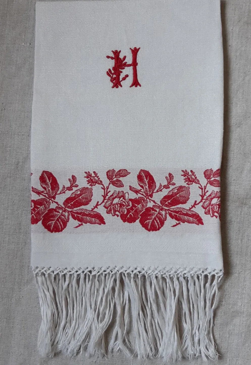Serviette dammassée rouge et blanc avec initiale "h"