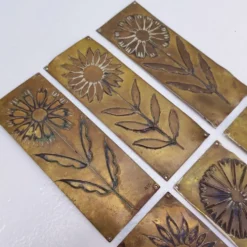 Six plaques de propreté, décor fleurs, laiton