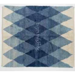Tapis en laine contemporain avec des diamants bleus entrelacés.
