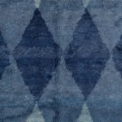 Tapis en laine contemporain avec des diamants bleus entrelacés.