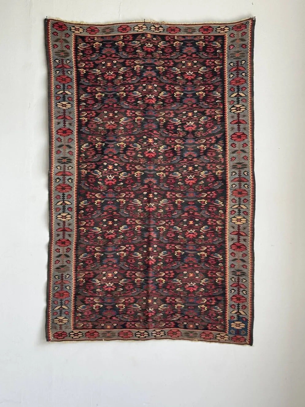 Tapis iranien à motifs floraux stylisés roses et bleus 155x105