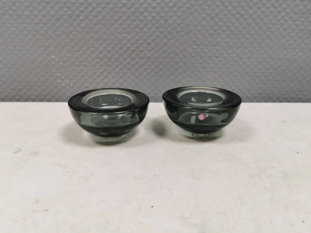 Un ensemble de porte-bougies iittala en verre transparent fumé.