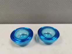 Un ensemble de porte-bougies iittala en verre transparent bleu.