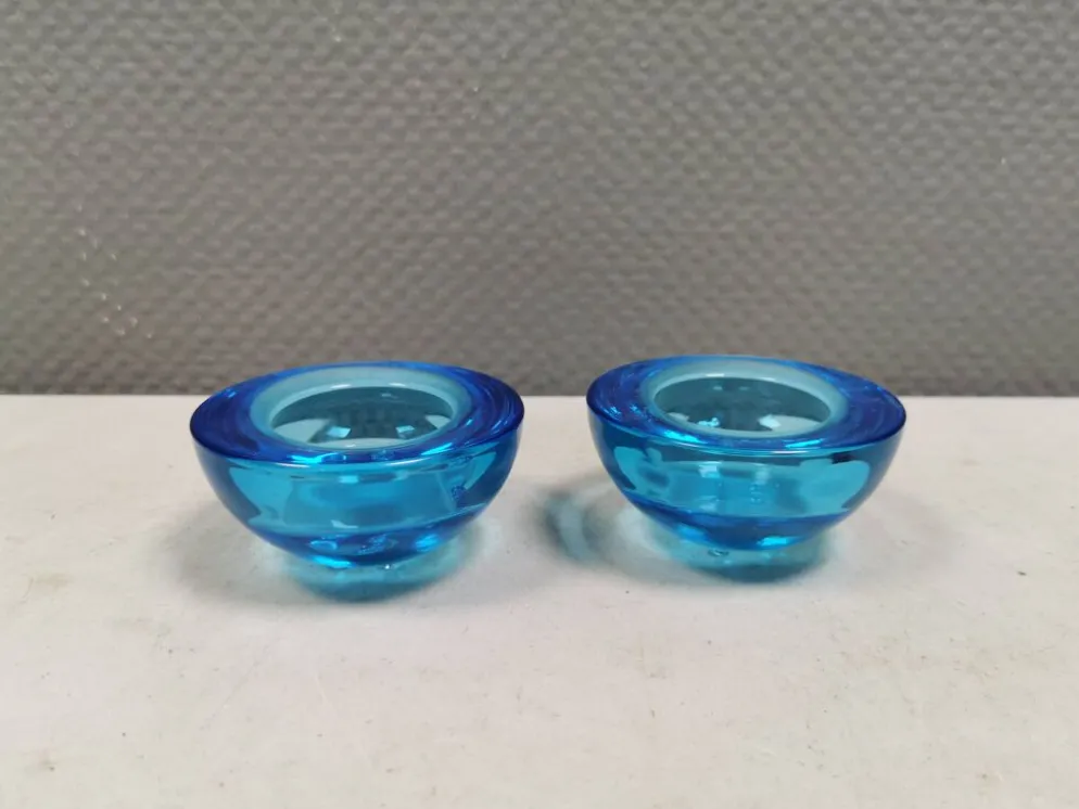 Un ensemble de porte-bougies iittala en verre transparent bleu.