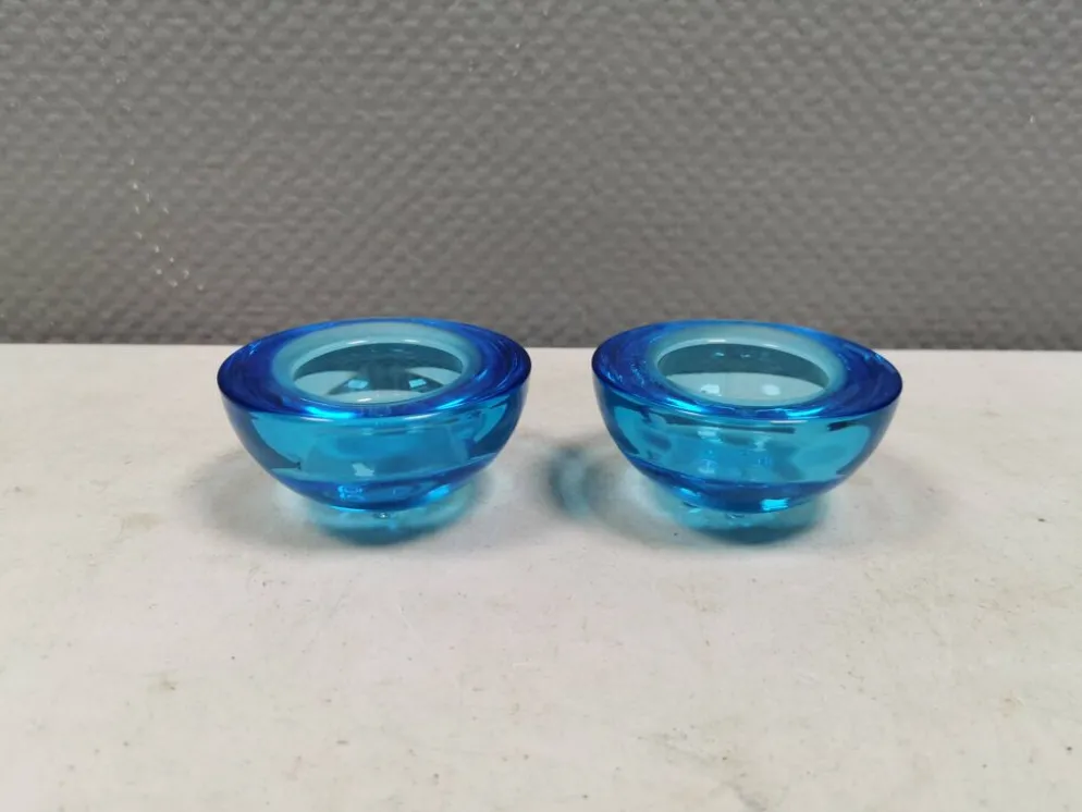 Un ensemble de porte-bougies iittala en verre transparent bleu.